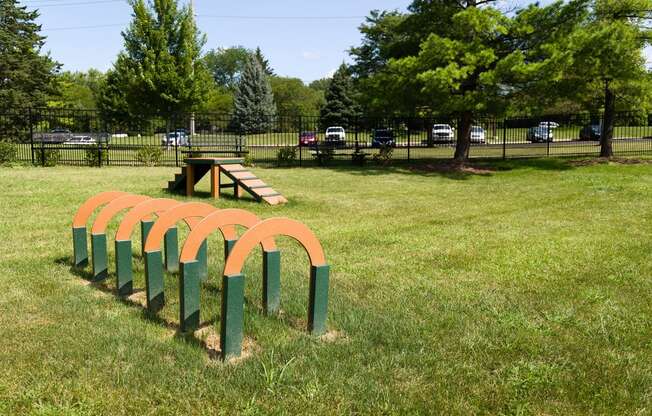 a park with a playground and a bench in the grass