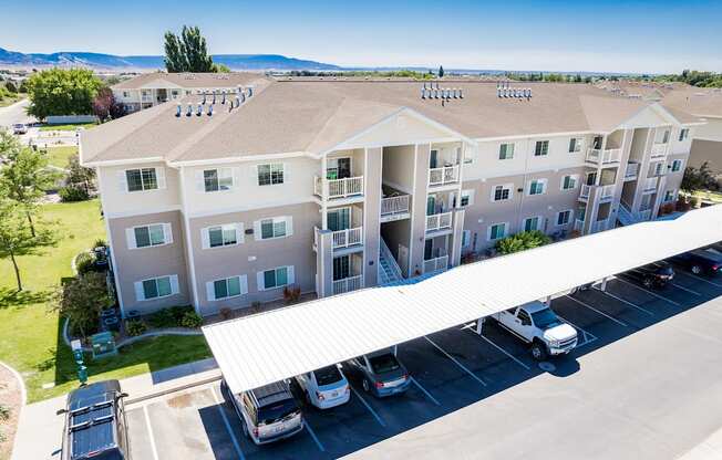 A large apartment complex with a parking lot in front.