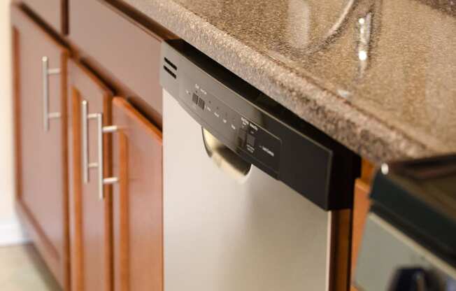a dishwasher in a kitchen with a granite counter top at penn view apartments in washington dc