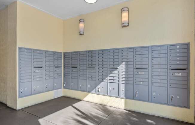 an empty locker room with blue lockers on the wall and a staircase