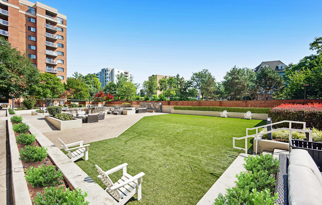 A well-maintained outdoor area with a grassy field, benches, and a fence.