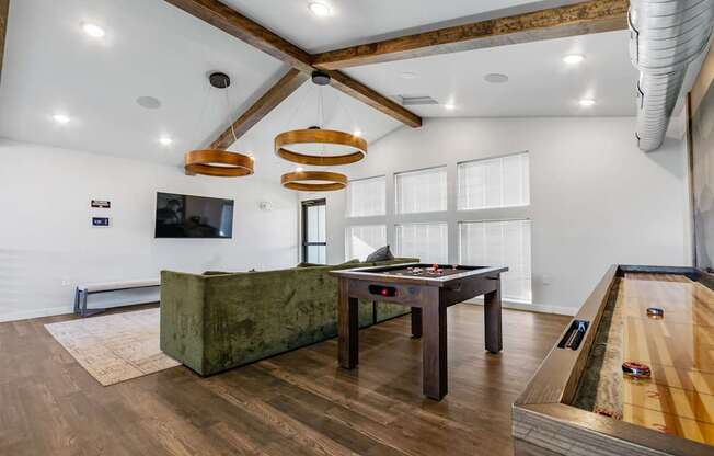A room with a pool table and a green couch.