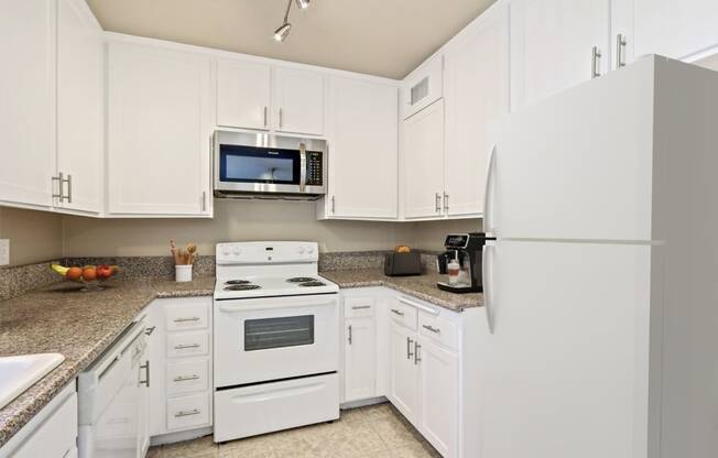 a kitchen with white appliances and white cabinets