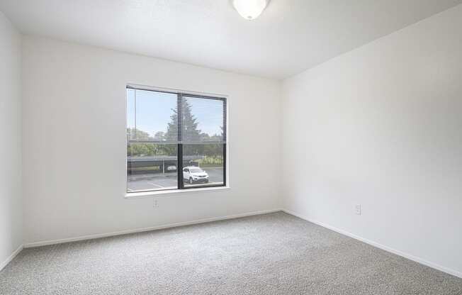 an spacious bedroom with a large window and carpeting at North Pointe Apartments in Elkhart, IN