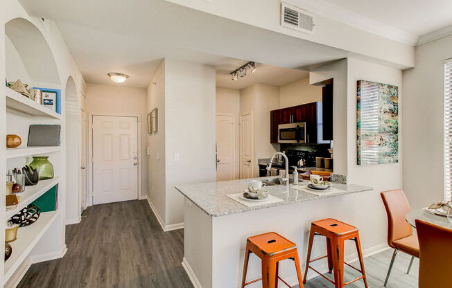 staged kitchen with hardwood-style flooring and bar seating