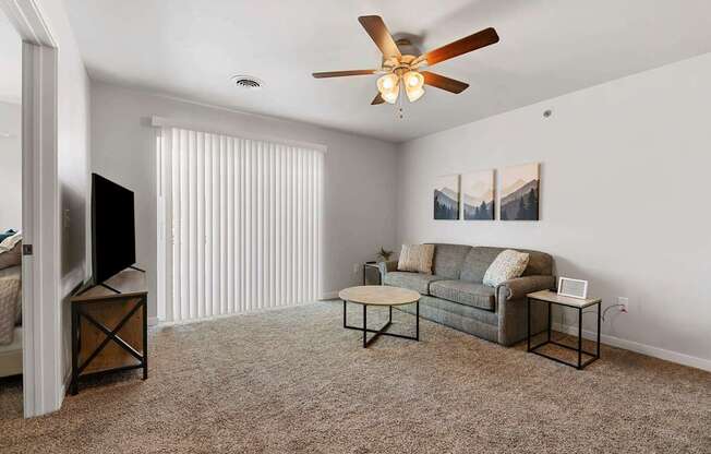 a living room with a couch and a ceiling fan at Red Rock Apartments, Rapid City, SD