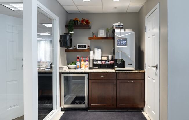 a kitchen with a coffee maker and a counter with a refrigerator