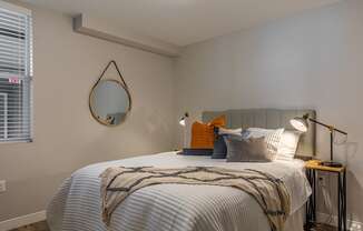 a bedroom with a large bed and a mirror on the wall