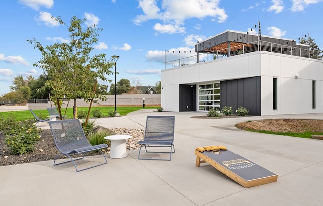 a patio with two chairs and a coffee table in front of a building