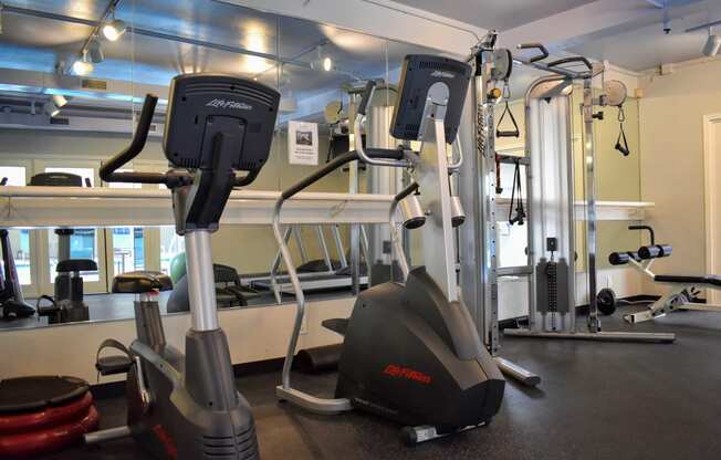 View of community gym featuring stationary bike, stair stepper, and weight machine