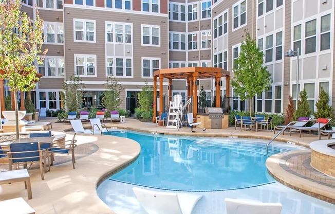 a swimming pool in a courtyard with an apartment building in the background