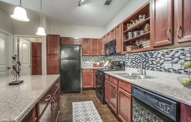 Kitchen with Wood Cabinets and Granite Countertops  at Overlook at Stone Oak Park Apartments, San Antonio, Texas