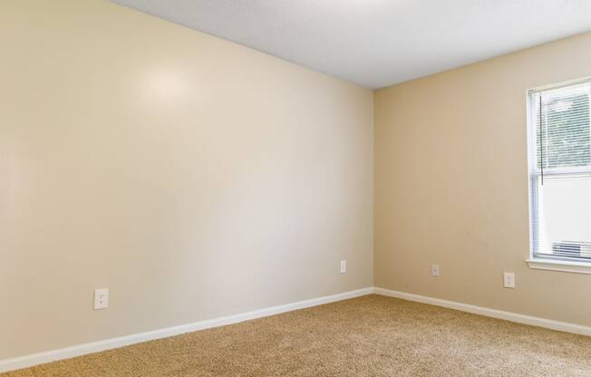 a bedroom with beige walls and a window