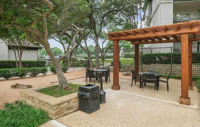 A patio area for al fresco dining with tables and chairs at Jefferson Place Apartments in Irving, TX