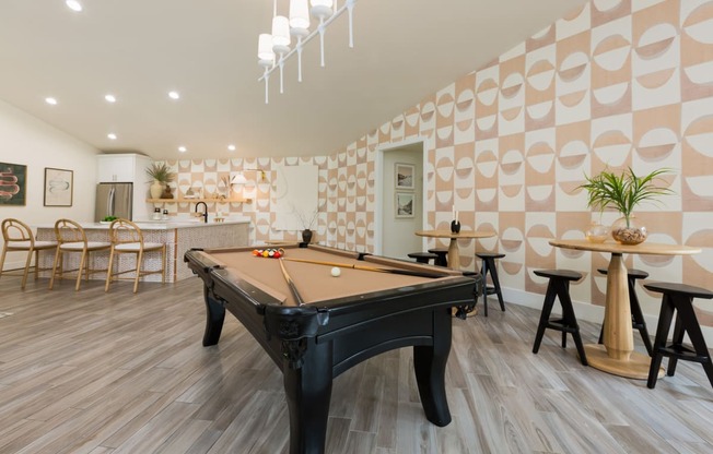 a billiards table in a clubhouse with a bar and tables