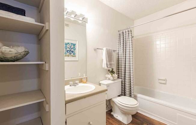 A white bathroom with a toilet, sink, and shower.