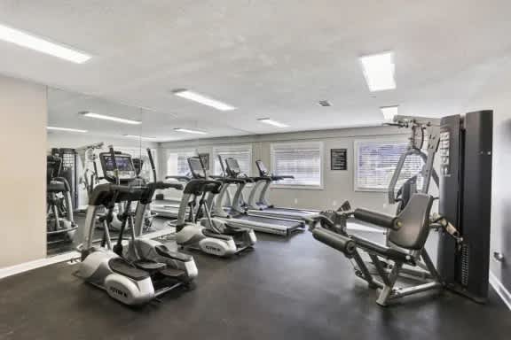 A gym with treadmills, elliptical machines, and other exercise equipment.