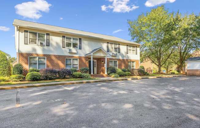 the front of an apartment building with a parking lot