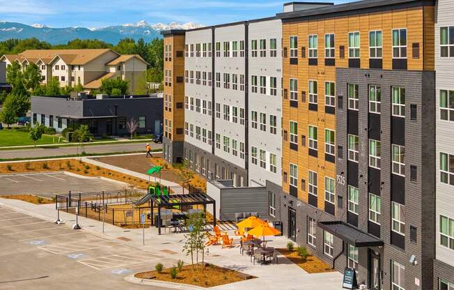 A modern apartment complex with a parking lot in front.