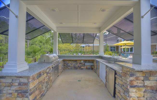 Poolside kitchen with grill and bar at Lullwater at Blair Stone apartments for rent