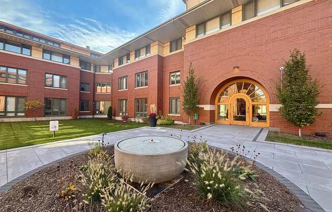 A large building with a circular planter in front of it.
