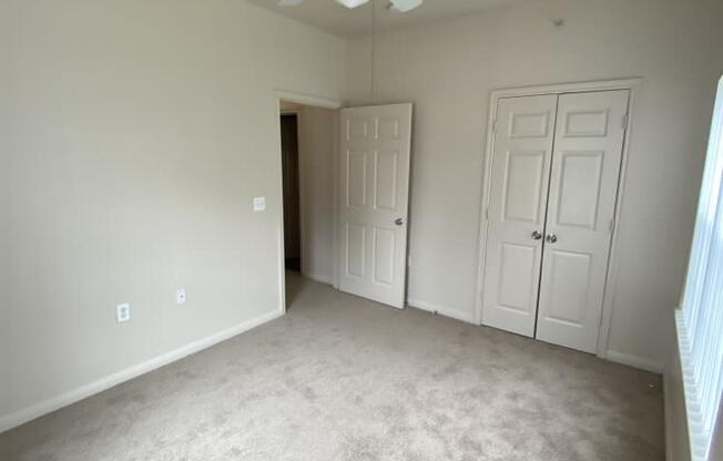 an empty room with a ceiling fan and a door