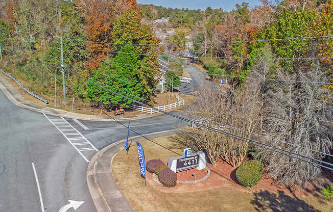 Element at 4411 Macon Apartments A road with a sign that says 4211 is surrounded by trees.