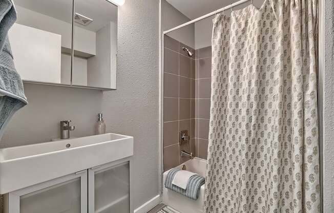 a bathroom with a shower and sink and a shower curtain