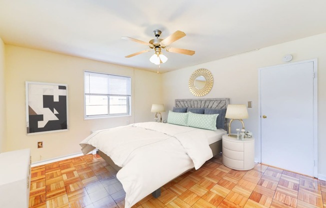 bedroom with bed, nightstands, hardwood flooring and ceiling fan at new horizon apartments in washington dc
