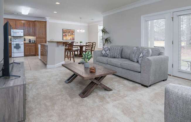A modern living room with a grey couch and a wooden coffee table.