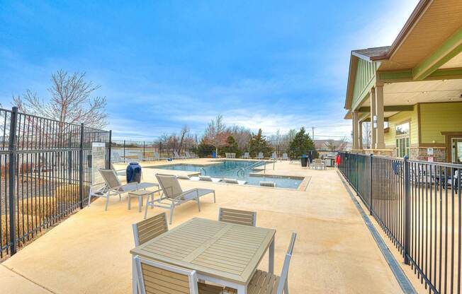 a patio with tables and chairs next to a pool