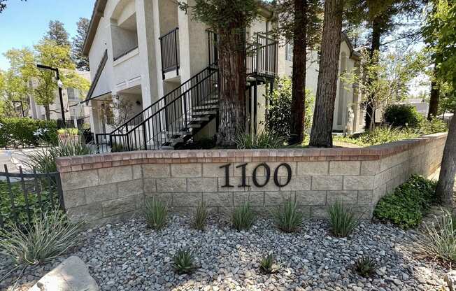 a house with a stone wall with the number 100 on it