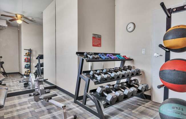 a gym with weights and dumbbells in the corner of a room