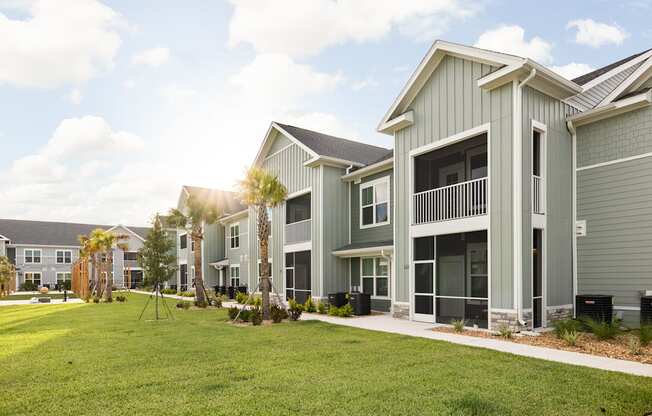 a row of houses with grass and palm trees in front of them at Palm Grove in Ellenton, FL 34222