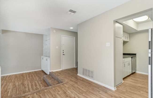 a kitchen and living room with a hard wood floor