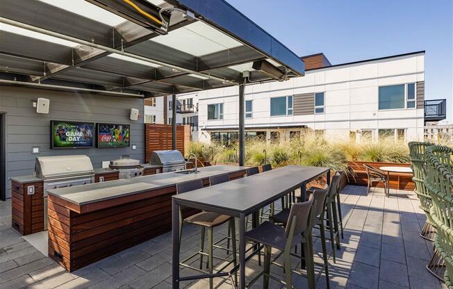 a patio with a table and chairs and a grill