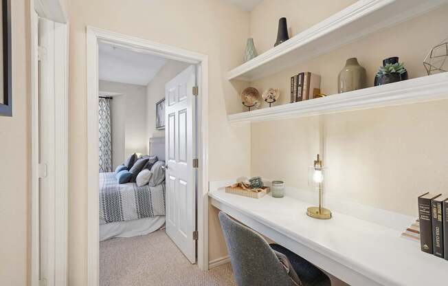 A white desk with a lamp and books on it.