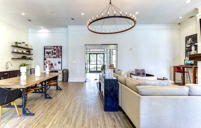 A modern living room with a wooden floor and a large chandelier.