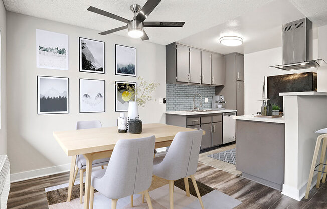 Hardwood floored dining room with ceiling fan and view of kitchen.