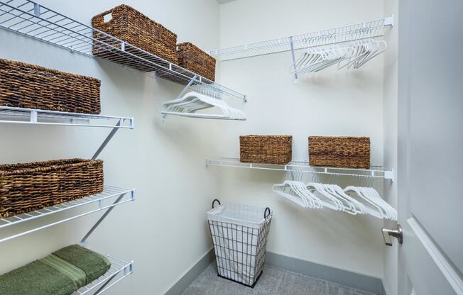 a closet with shelves and baskets and a basket in the corner