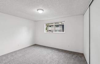 A room with a window and carpeted floor.