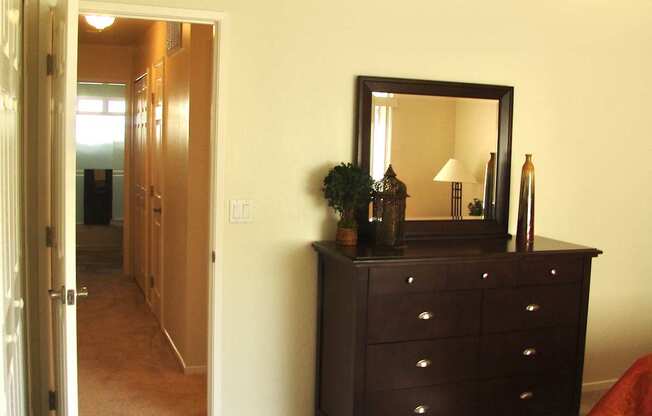 a bedroom with a dresser and a door to a hallway