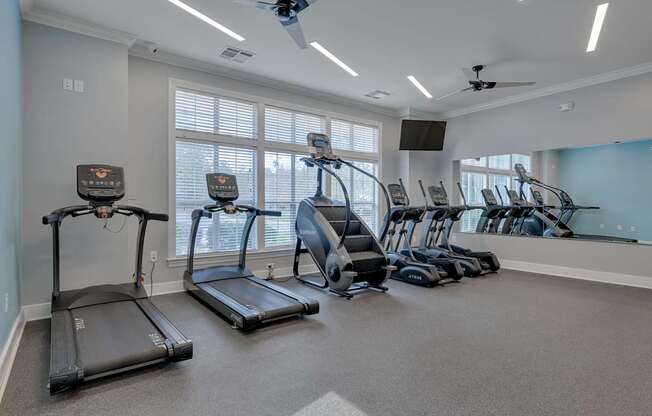 A spacious room with treadmills and elliptical machines.