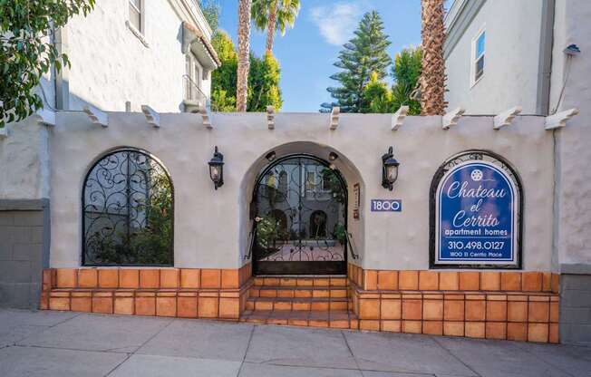 A white building with a blue sign that says Chateau El Cerrito.