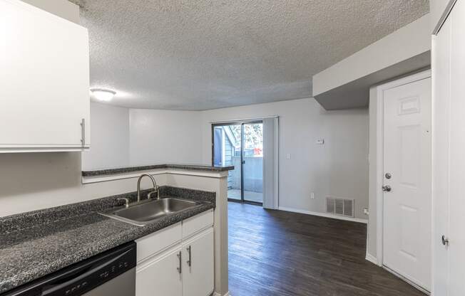 an open kitchen and living room with a sink and a window