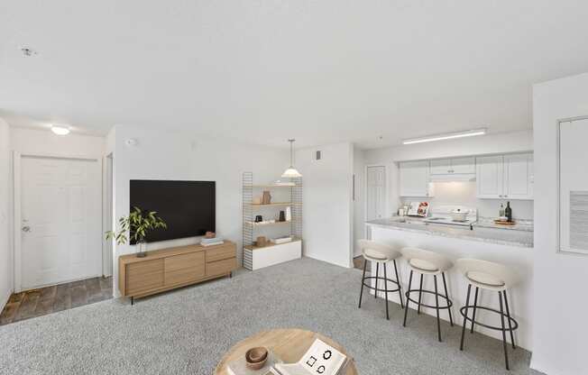 a living room with a kitchen in the background and a table and chairs in the foreground