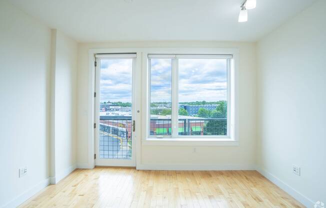 A room with a view of a parking lot through the windows at 603 Concord Apartments, Cambridge, Massachusetts