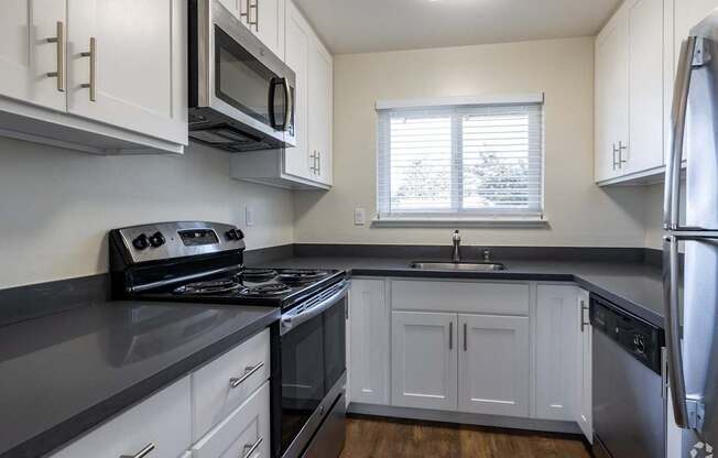 a kitchen with stainless steel appliances and white cabinets