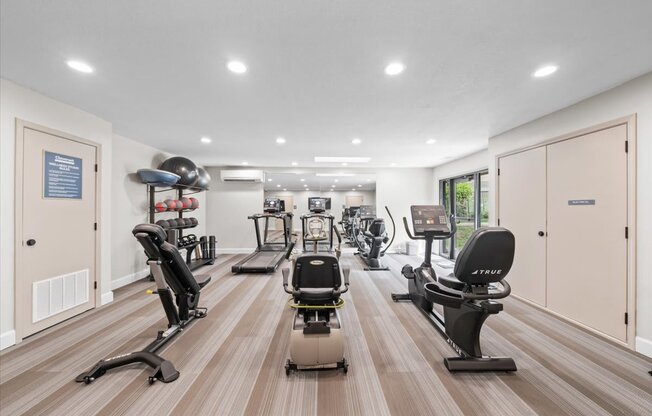 A gym with treadmills, stationary bikes, and elliptical machines.