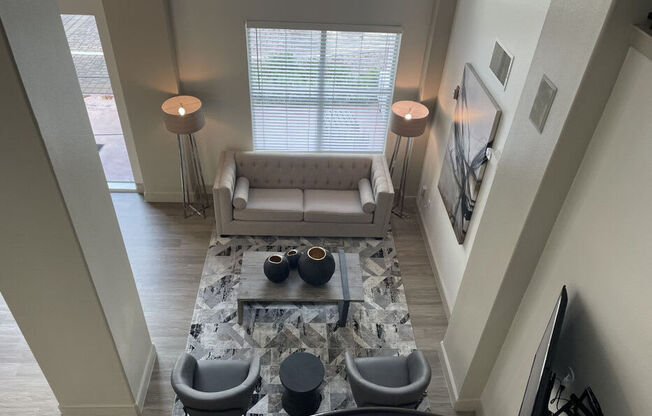 A living room with a couch, two chairs, and a coffee table.